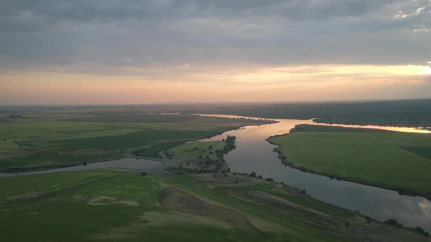 Aerial shot of a river winding through a dense green area