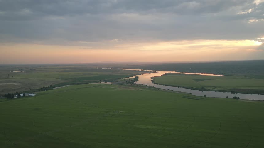 Aerial view of green pasture land with a winding river