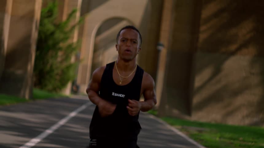 Determined man with sweaty body running in tank top outdoors