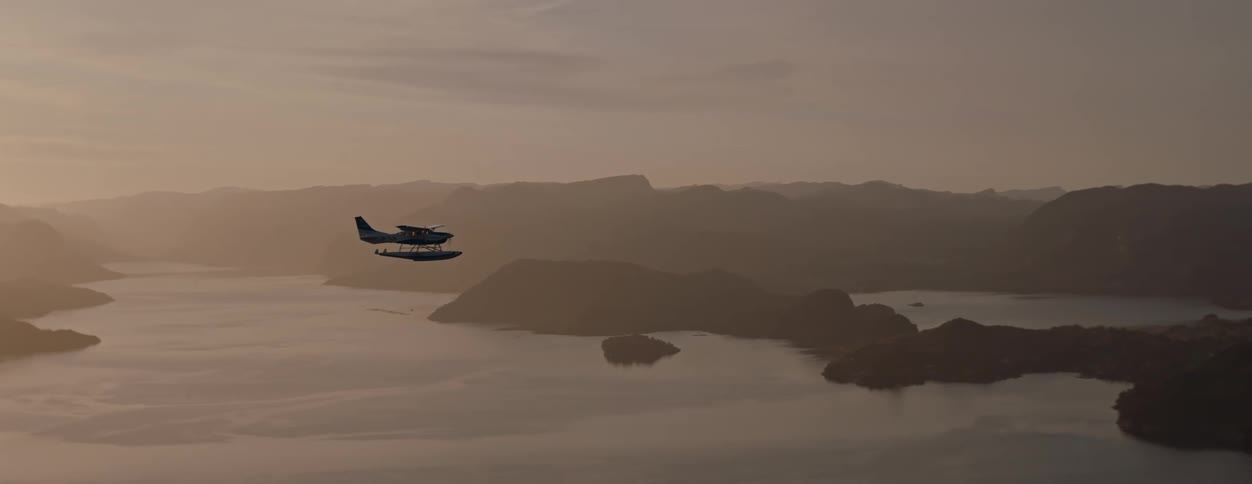 A water plane flies over a body of water