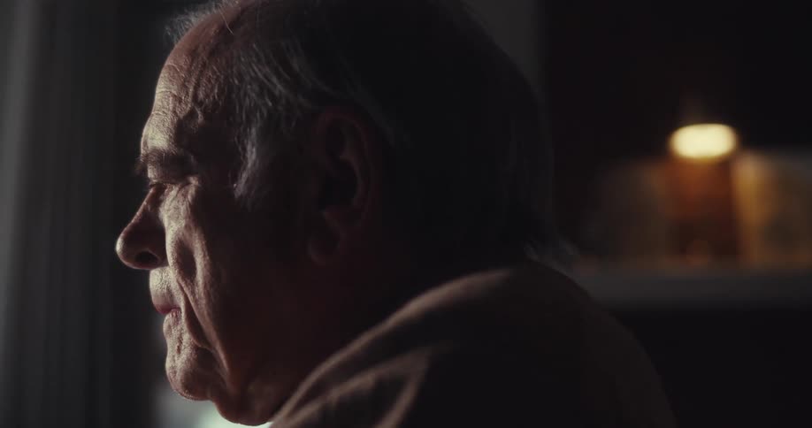 Side portrait of an elderly man sitting indoors