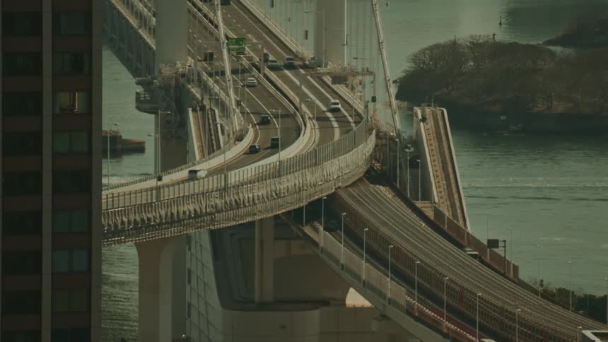 Man vehicles drive across a bridge over water