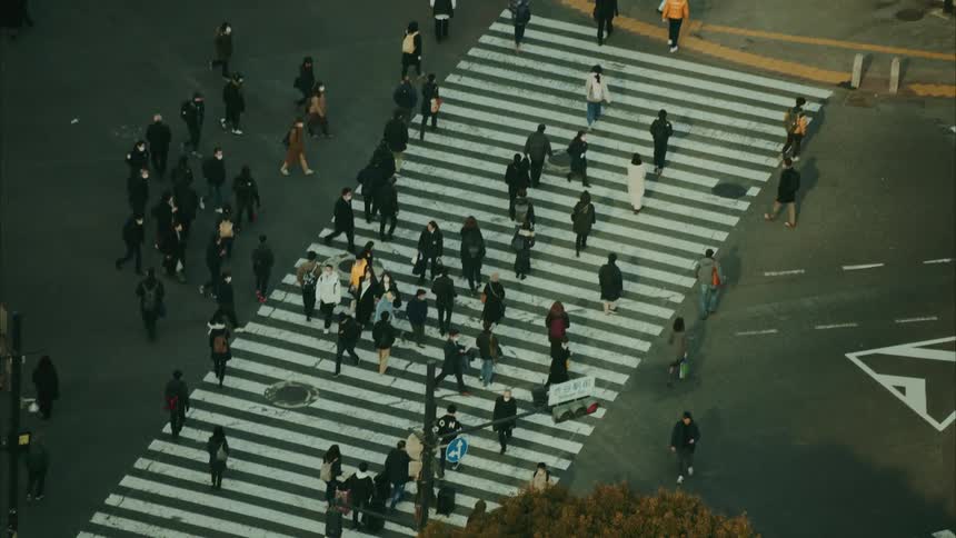 Pedestrians are walking through a populated city during the daytime