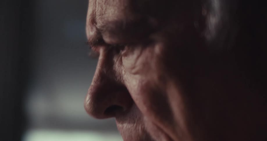 Elderly man sitting indoors during the day