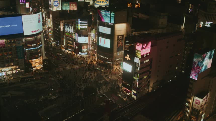Aerial of buildings cars and people moving around in a city at night