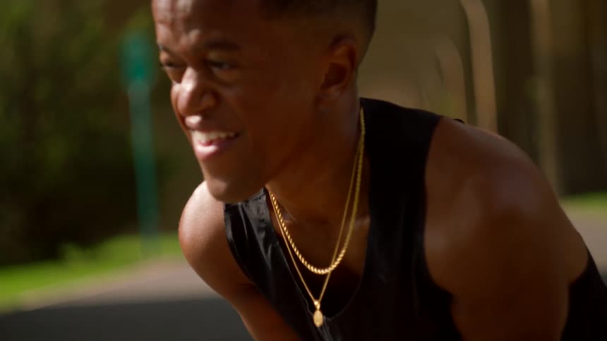 Man crouched down with a tired expression and a sweaty face