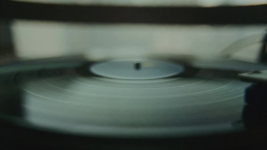 Record player spins a dark vinyl with needle positioned on it