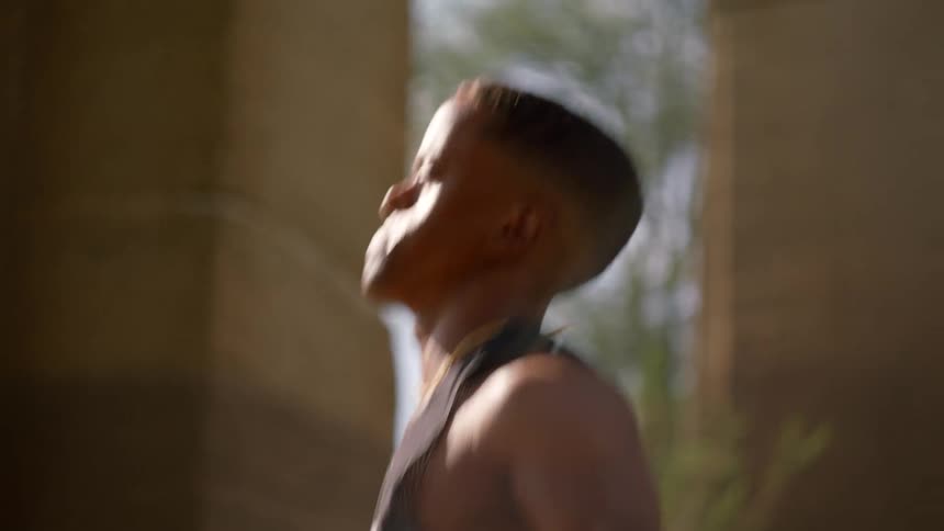 Close up of a black man doing jumping jacks outside during the day