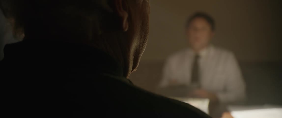 A man being interrogated by another man who is writing down everything he says