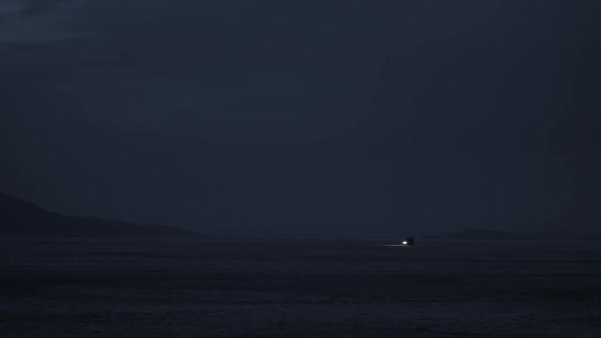 Vehicle driving across desert at night