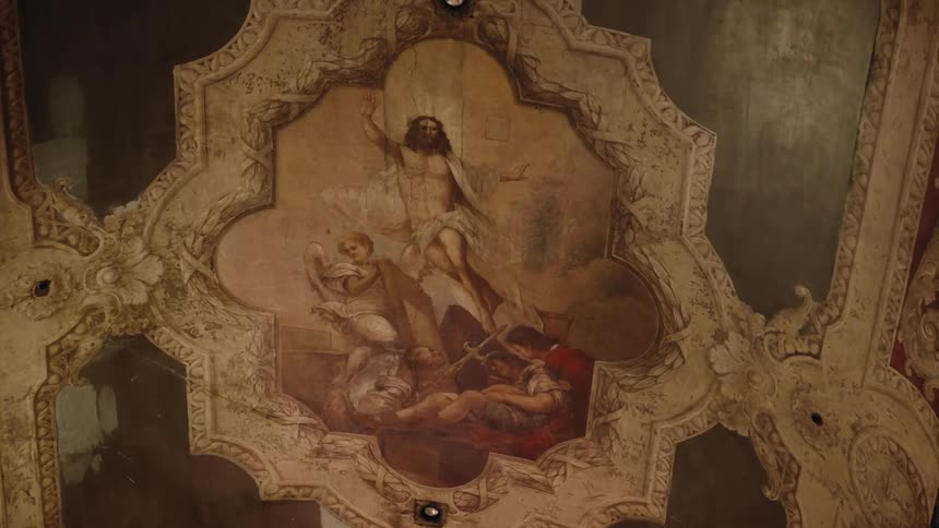 An old painting of a man and angels on a ceiling