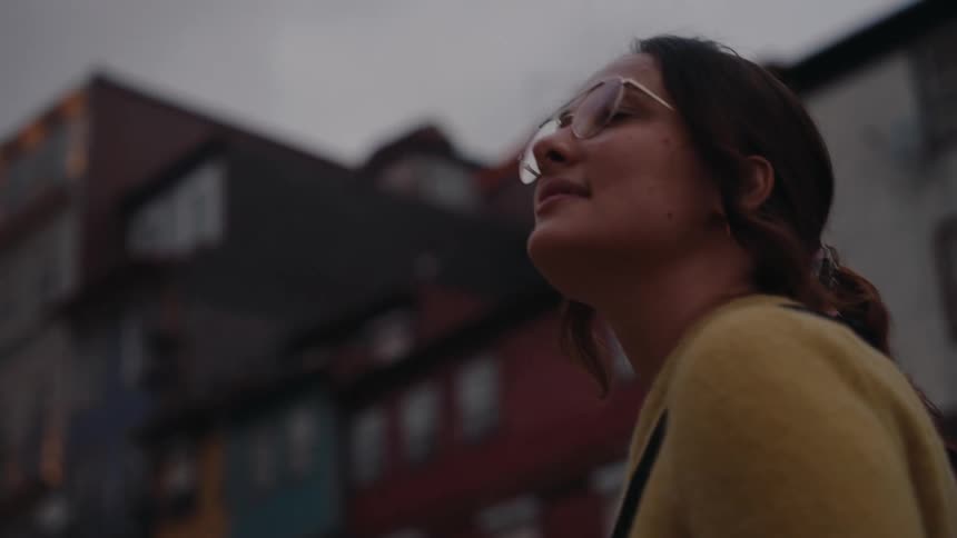 A tourists smiles as she views the buildings in town