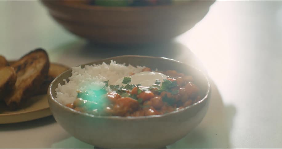 Showing a close up of a bowl with rice and stew with toast on the side