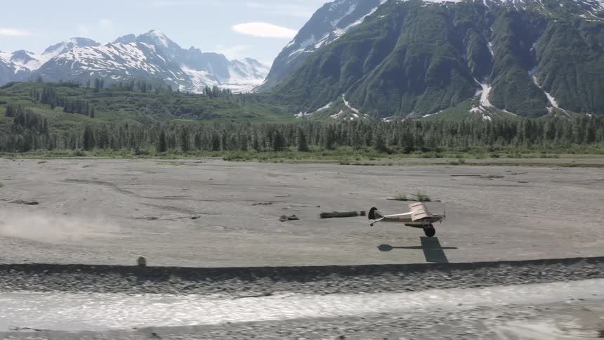 The plane takes off and flies towards the mountain