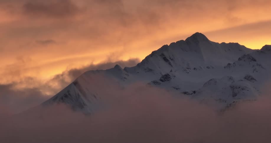 An ice mountain dense clouds and a sunset