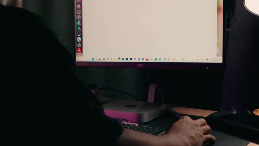 Person sitting in a room interacting with a desktop computer