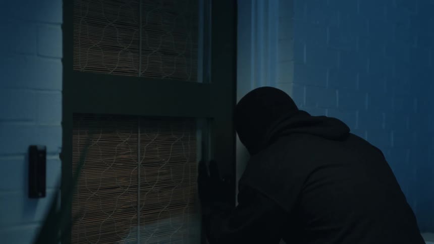 Hooded thief trying to break down a door