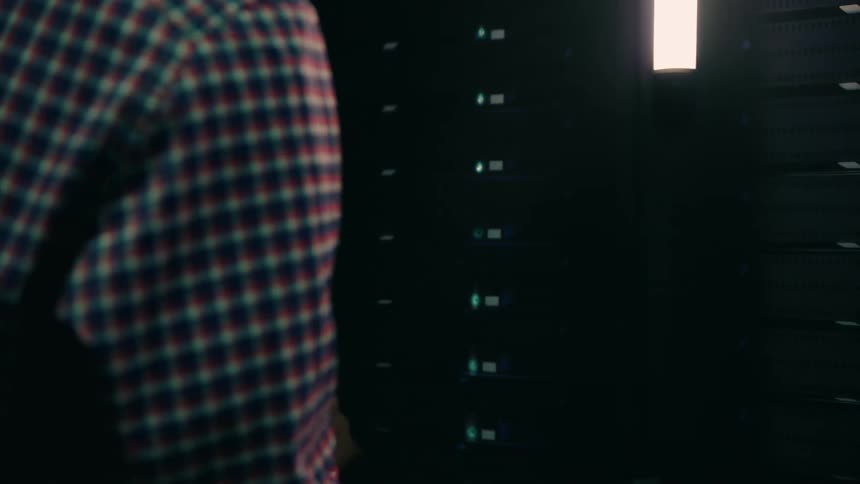 A man presses a button on the server rack