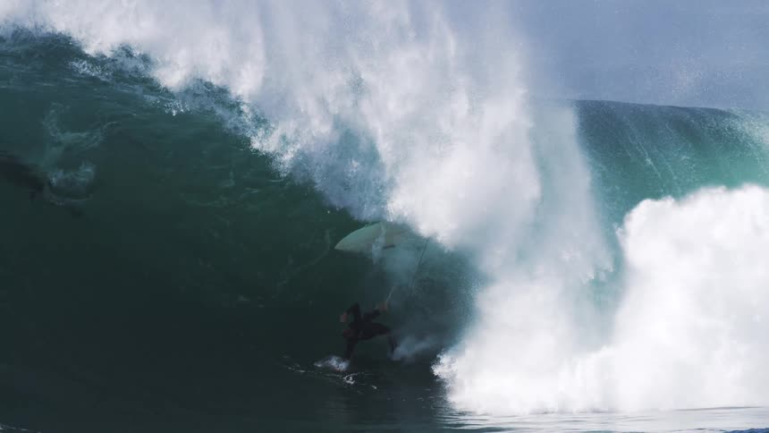 Man surfing inside a falling tubular wave