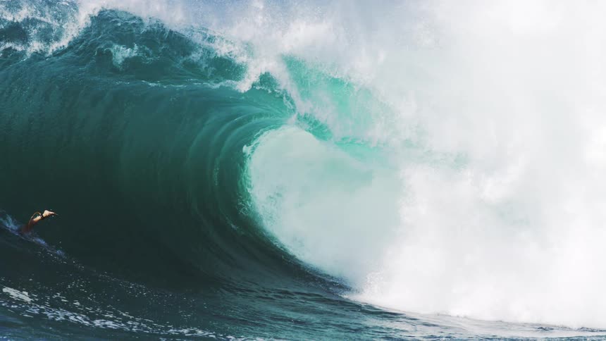 Surfer diving into a tubular wave