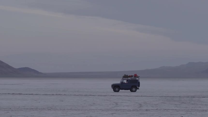 A jeep driving past mountains