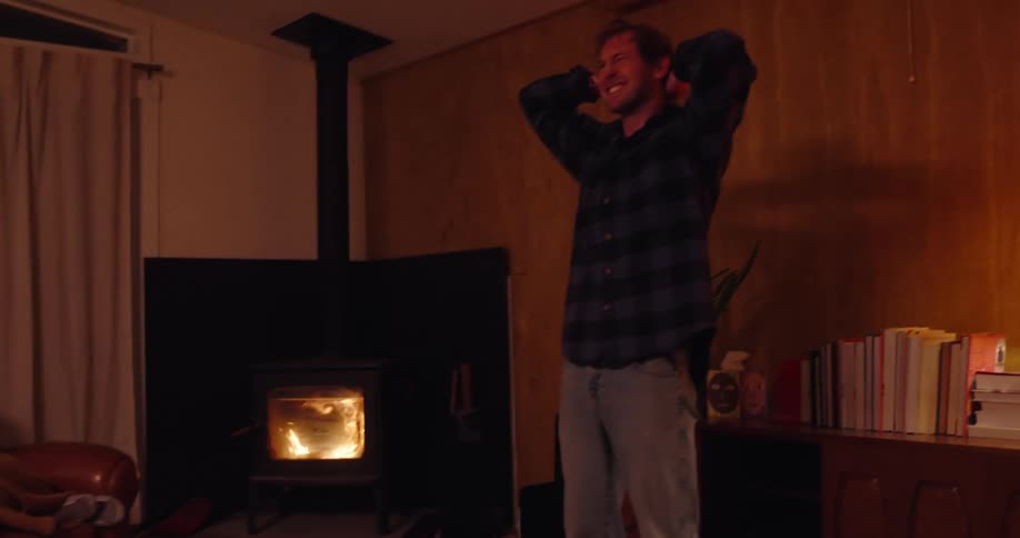 Playing charades with friends in a rustic cabin near a woodstove fireplace