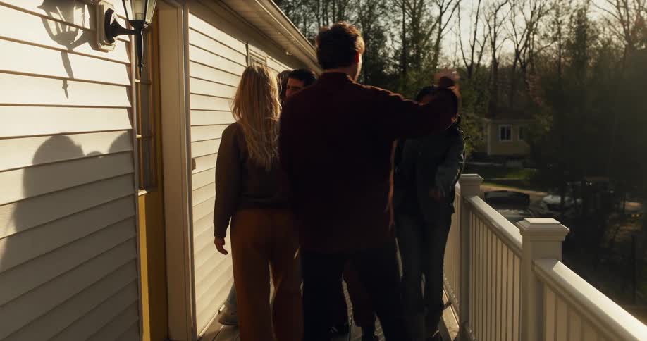 Group of friends embrace at the entrance balcony of a building