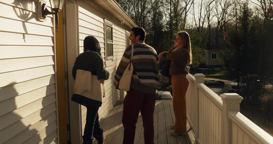 A dog brings a ball to people exiting the home