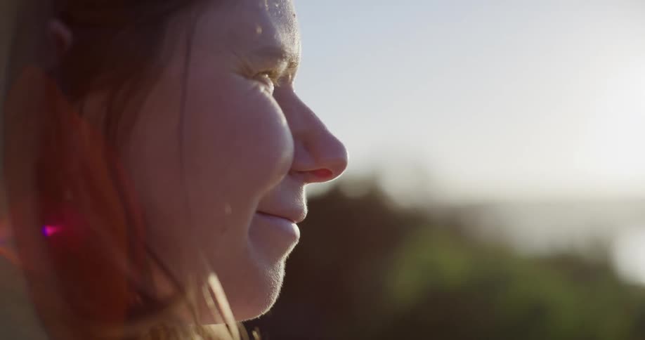 Closeup of woman as she sips from a cup and smiles afterwards