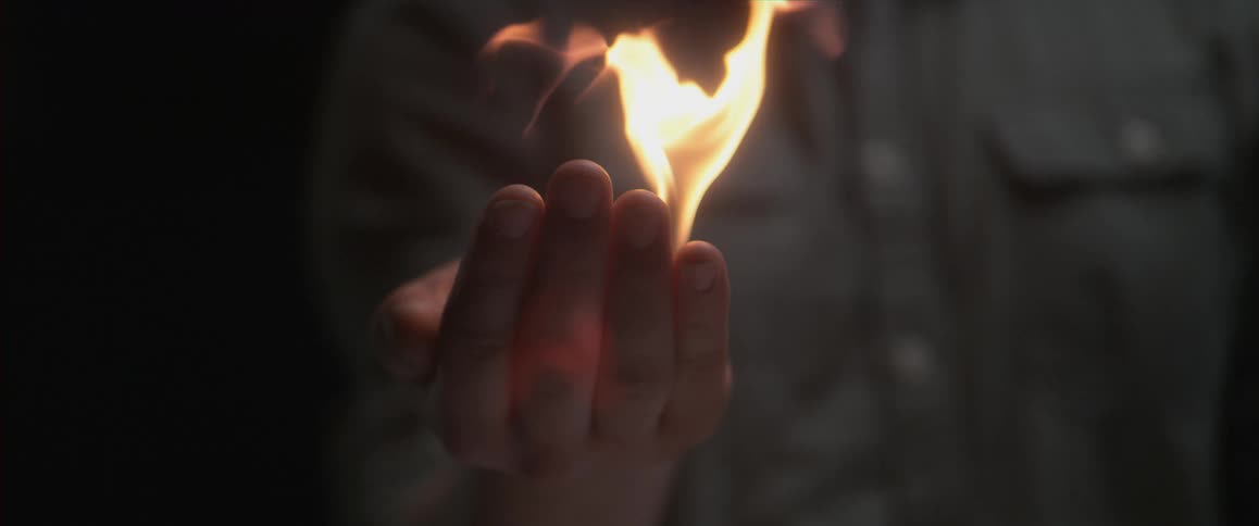 A person holding a flame in their hand