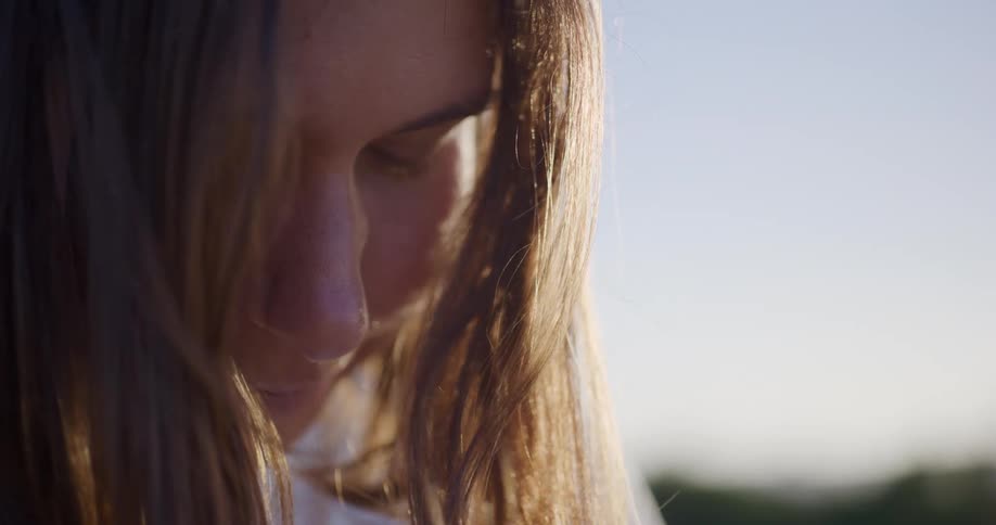 Woman upside down with her hair blowing in the wind in an outdoor setting