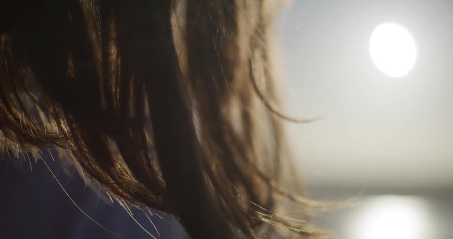 Close up of a womans hair outdoors with sun reflection