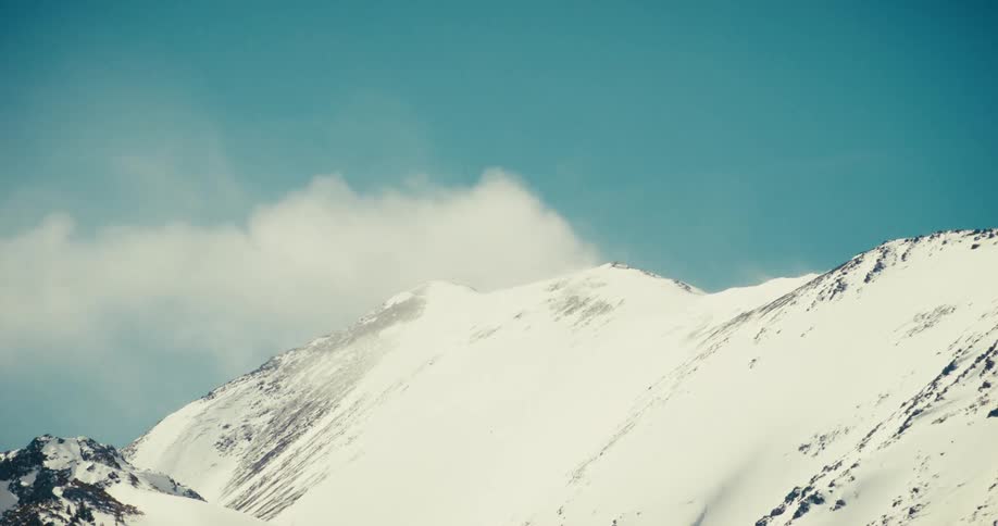 Mountain top against a cloudy sky during the day in winter