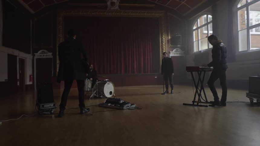 Musical group consisting of four men in a rehearsal in a hall during the day