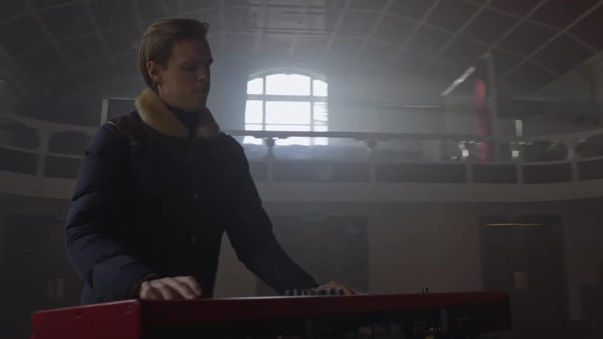 A man playing a keyboard and another man beside him playing a guitar