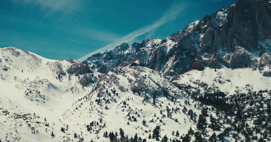 Aerial landscape of mountains with sparse vegetation covered by snow