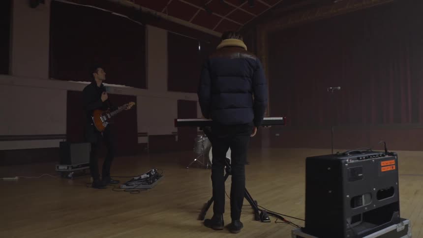 A band is setting up in the auditorium