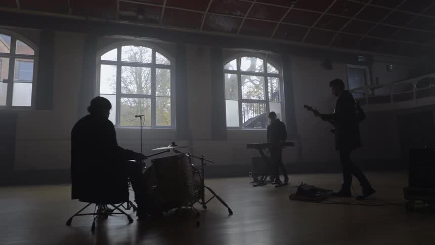 Male musical group rehearsing in a hall
