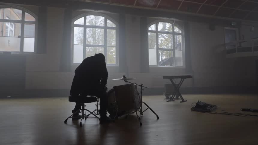 A person sits down at a drum set