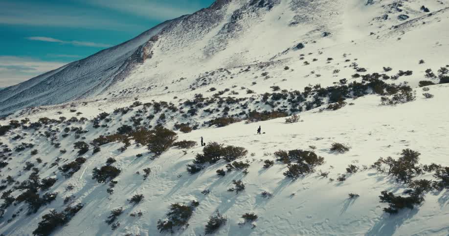 Aerial shot of few people on a snowy mountain