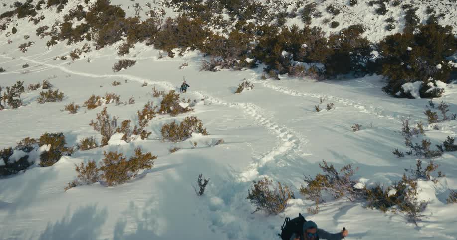 Aerial view of people climbing a snowy mountain