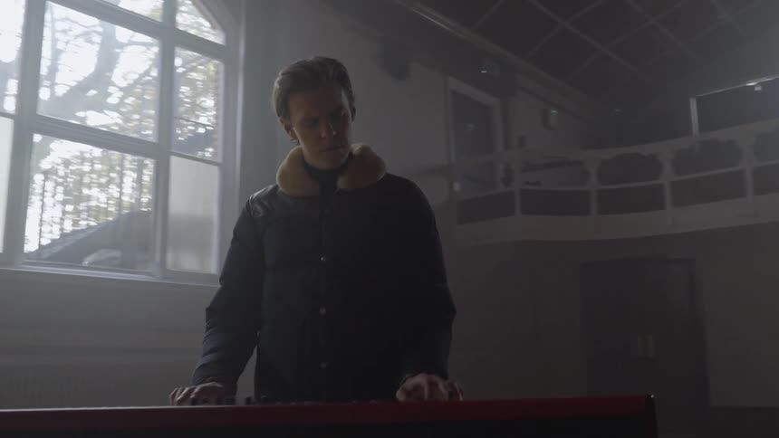 Man nods as he plays a keyboard while rehearsing with a band
