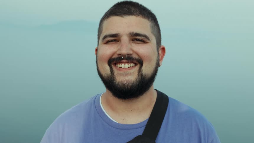 Portrait of a man smiling in front of a blue background