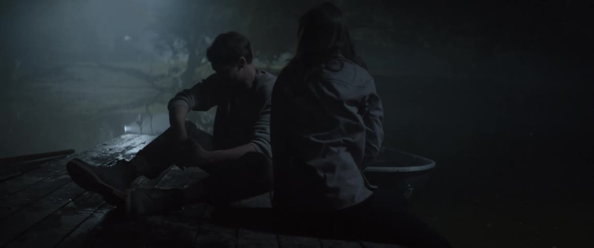 Woman sitting on a dock at night with a man turns and slaps him