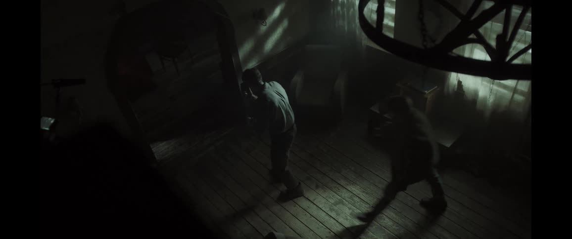 Silhouette of two people inside a dimly lit house