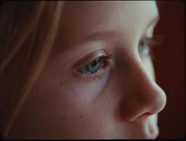 Young blonde haired female stares while indoors