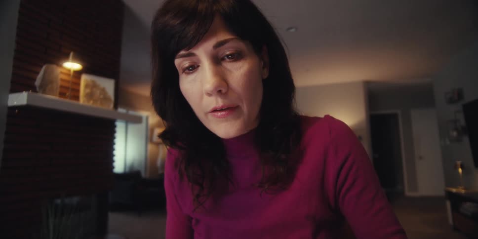 Woman sitting holding a pen with a concentrated expression
