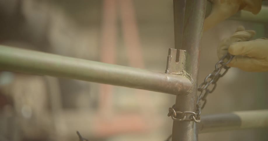 A metal fence is opened by a person