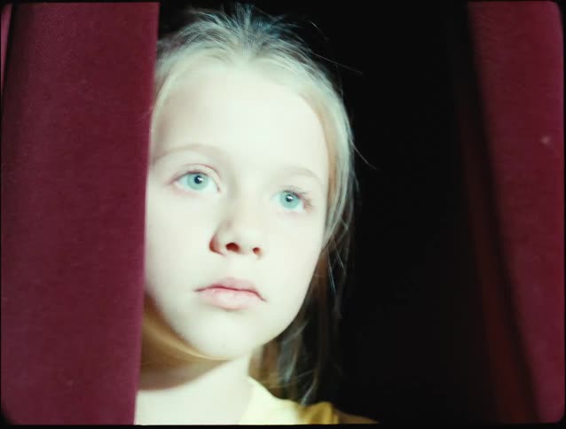 Portrait of a blonde girl with light eyes and flashing lights on her face