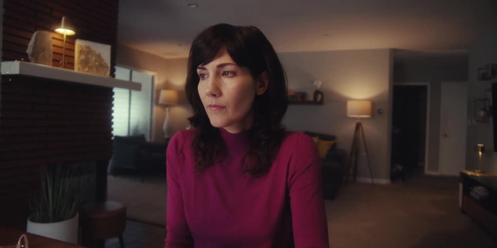 Woman sitting thoughtfully in a room of the house